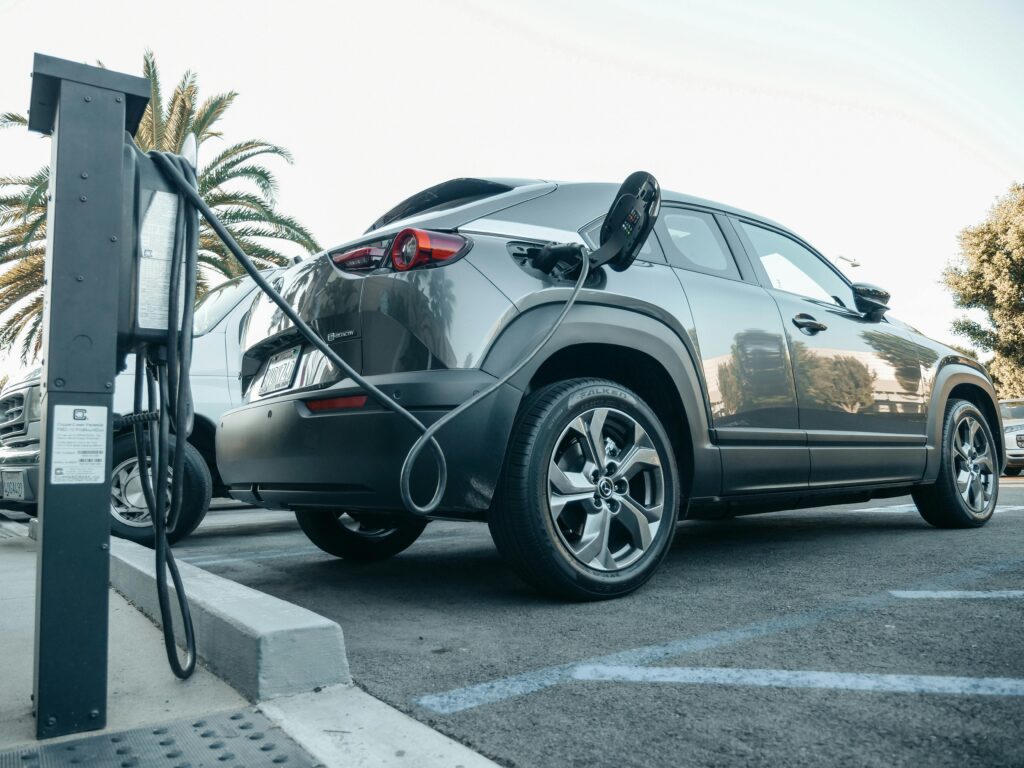 Modern electric vehicle charging at an outdoor station in daylight.